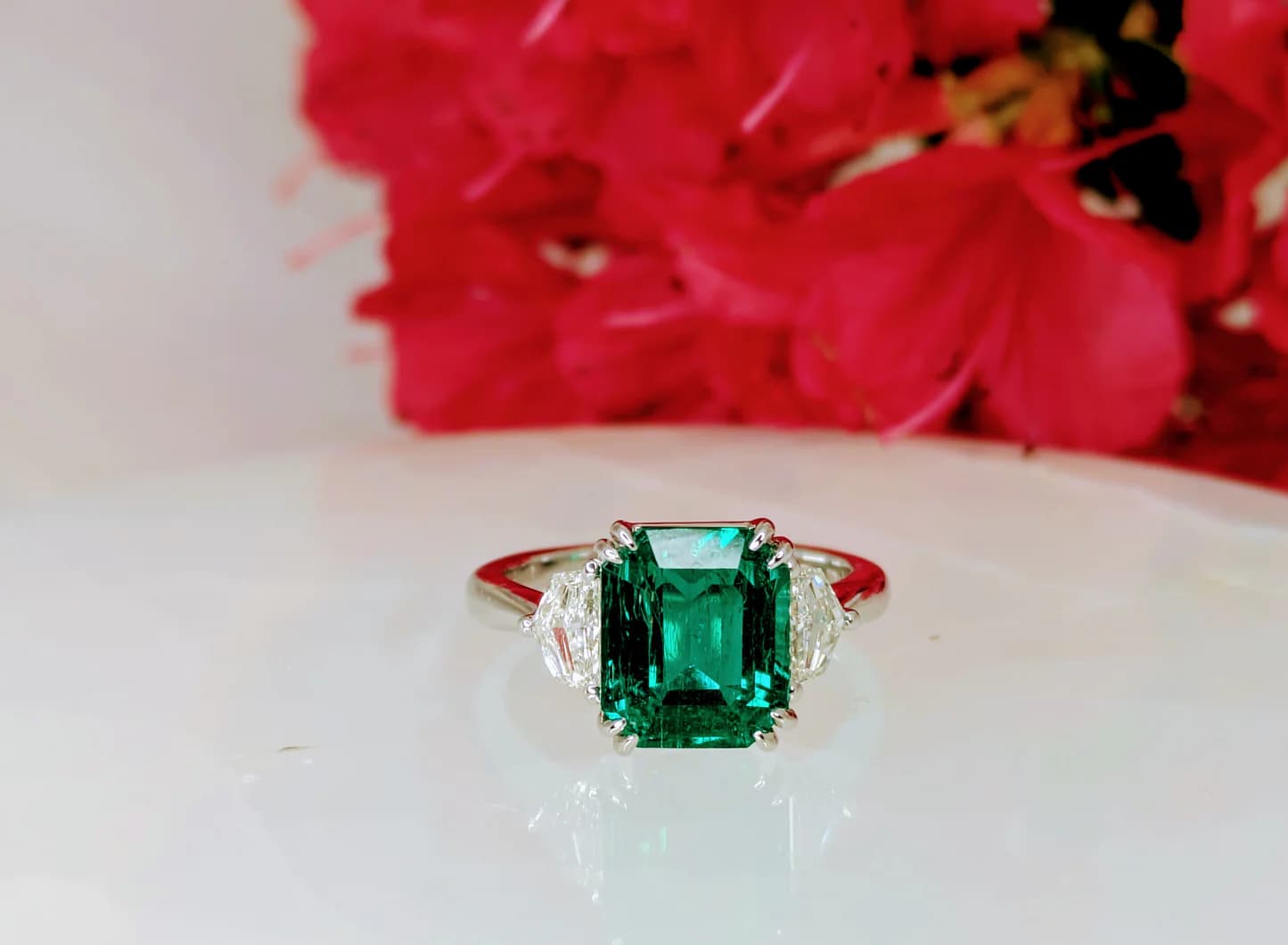 Emerald-cut Colombian emerald flanked by diamond half-moons set in platinum