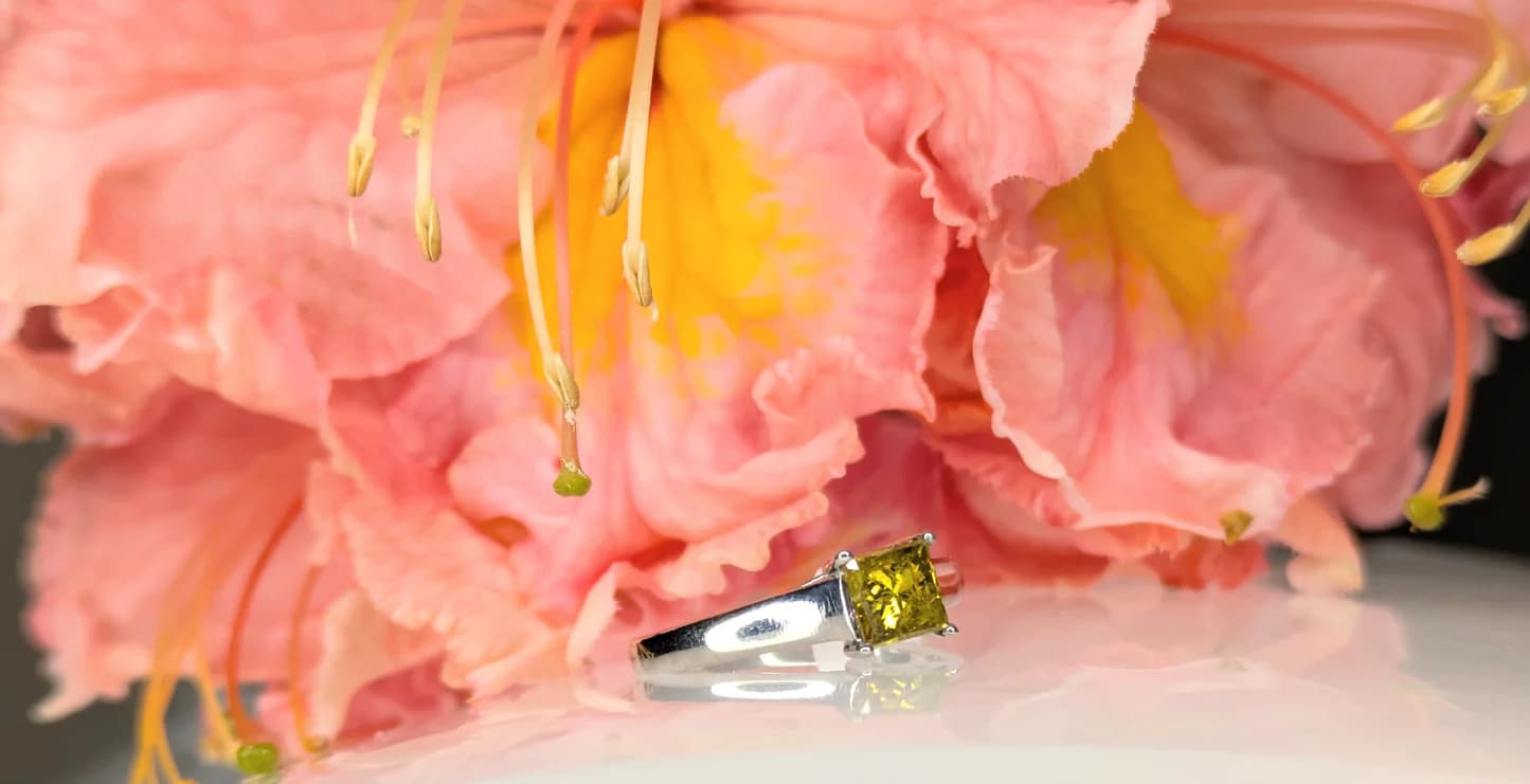 Citrine princess-cut ring resting against pink hibiscus flowers